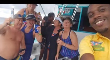 Guests laughing with drinks up on a Mowatt Tours boat day off Ocho Rios